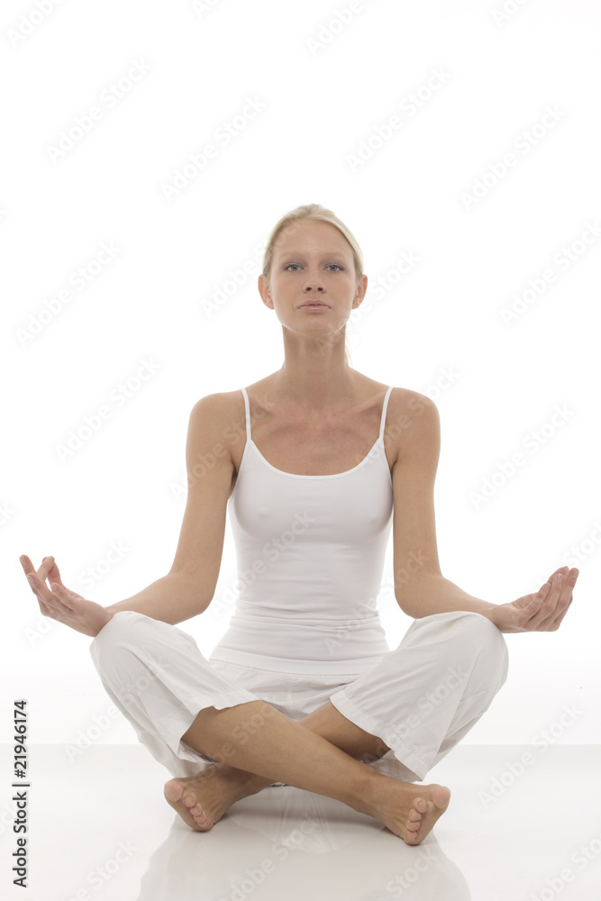 young woman dressed in white sitting cross-legged doing yoga