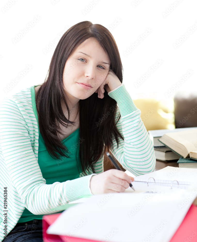 Tired attractive student sleeping while doing her homework Tired attractive student sleeping while doing her homework