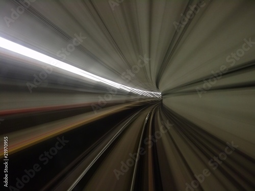 view of lighted tunnel at a turning from a fast moving train