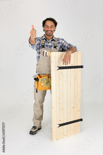 menuisier debout avec un volet en bois