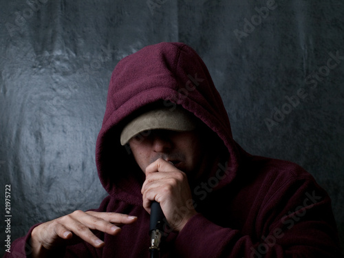 rapper wearing hood and singing to a microphone