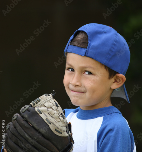 Young hispanic boy with baseball glove and blue hat