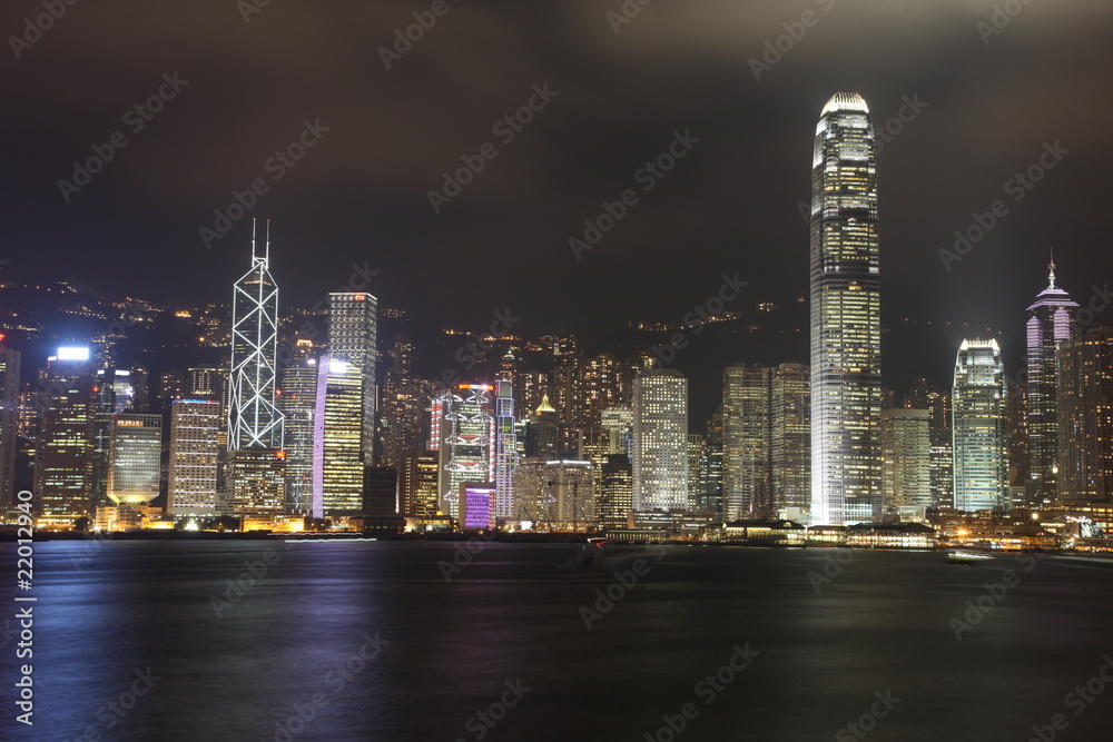 Illuminated Hong Kong Island skyline with reflections at night