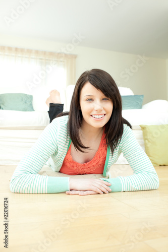 Attractive woman lying down on the floor in the living room