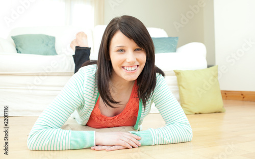 Radiant woman lying down on the floor in the living room
