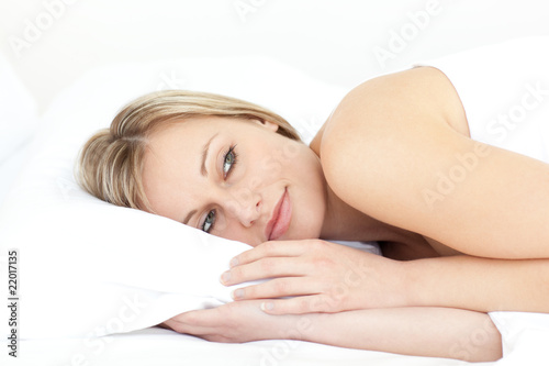 Bright young woman relaxing on her bed