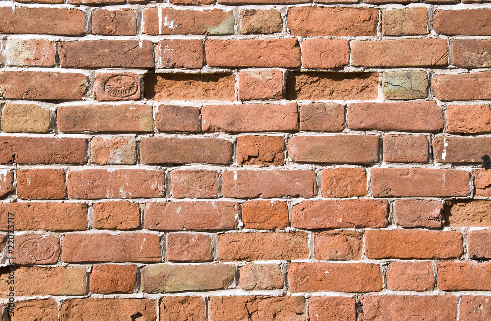 Obraz premium The old brick wall with broken stones.