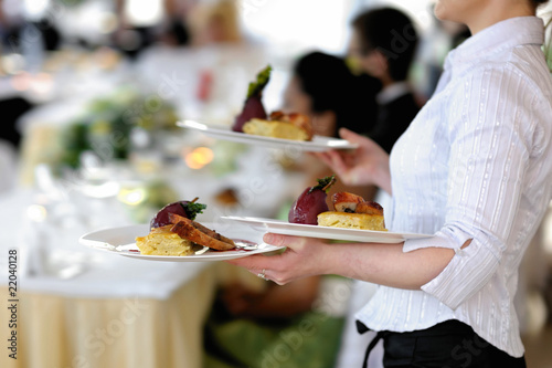 Waitress carrying three plates of delicious food