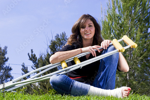 Fotobehang woman seated in park with crutches