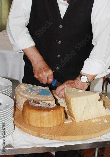 cameriere che taglia formaggi