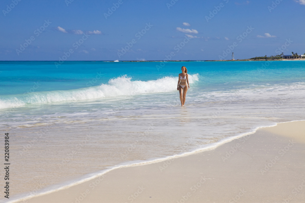 Young graceful woman goes on coast of ocean Young graceful woman goes on coast of ocean
