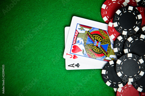 Black and red poker chips with cards in the background