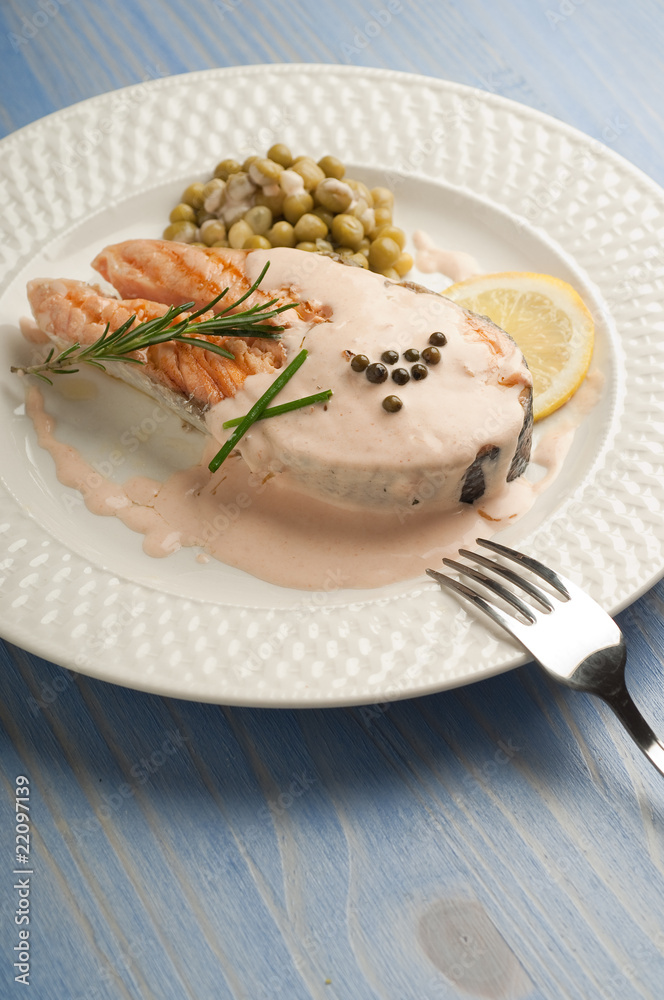 salmon with cream sauce on dish and fork salmon with cream sauce on dish and fork