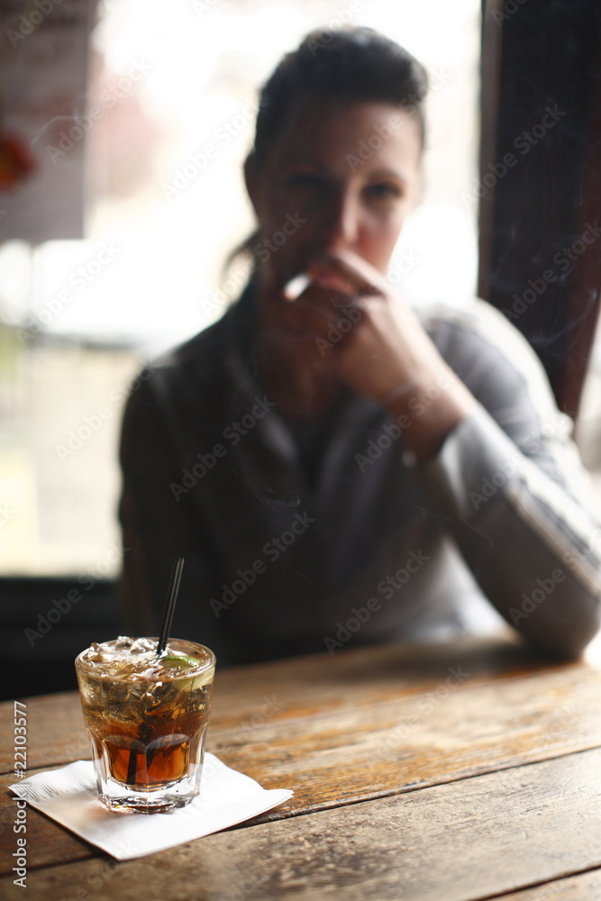 Woman with cocktail smoking cigarette