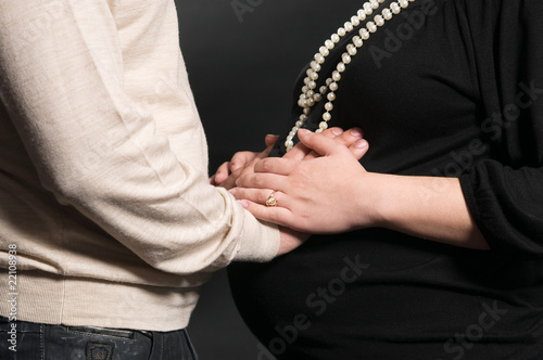 Men s hands on a belly of a pregnant woman