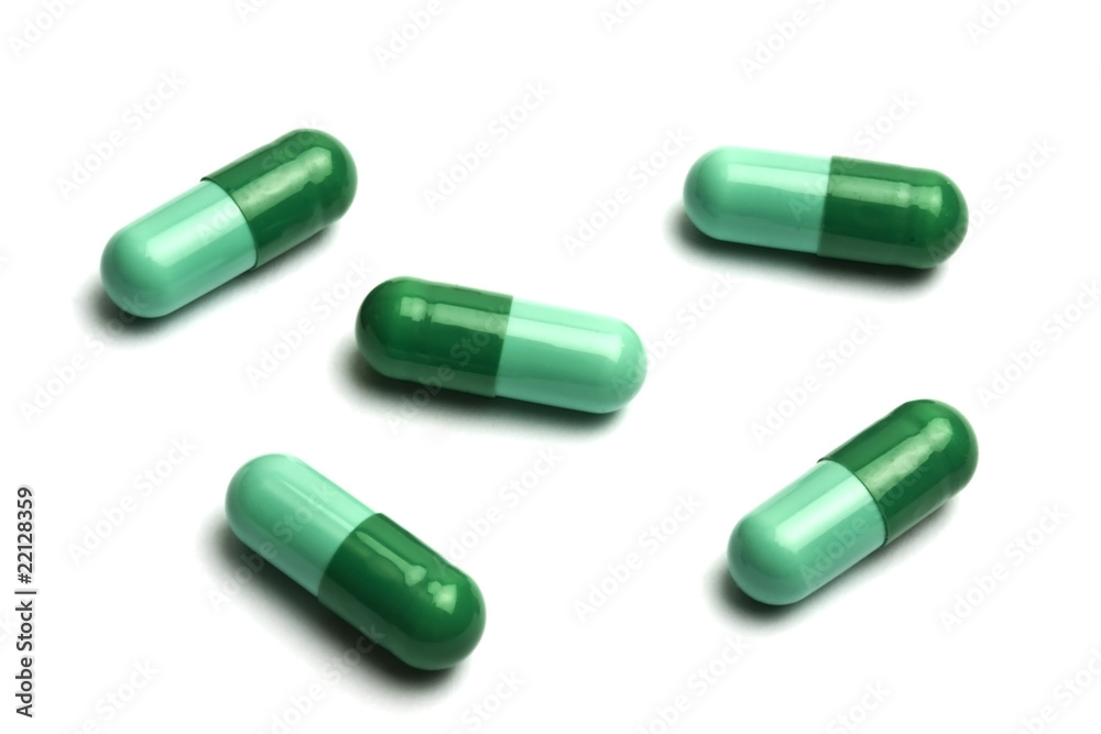 Green capsules on white background