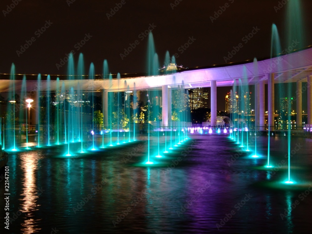 Water fountain with colourful light reflection at water surface