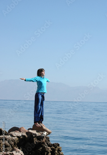 Freedom! Girl over the blue  sea with outstretched arms.