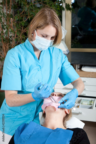 Female dentist working on her patient photo