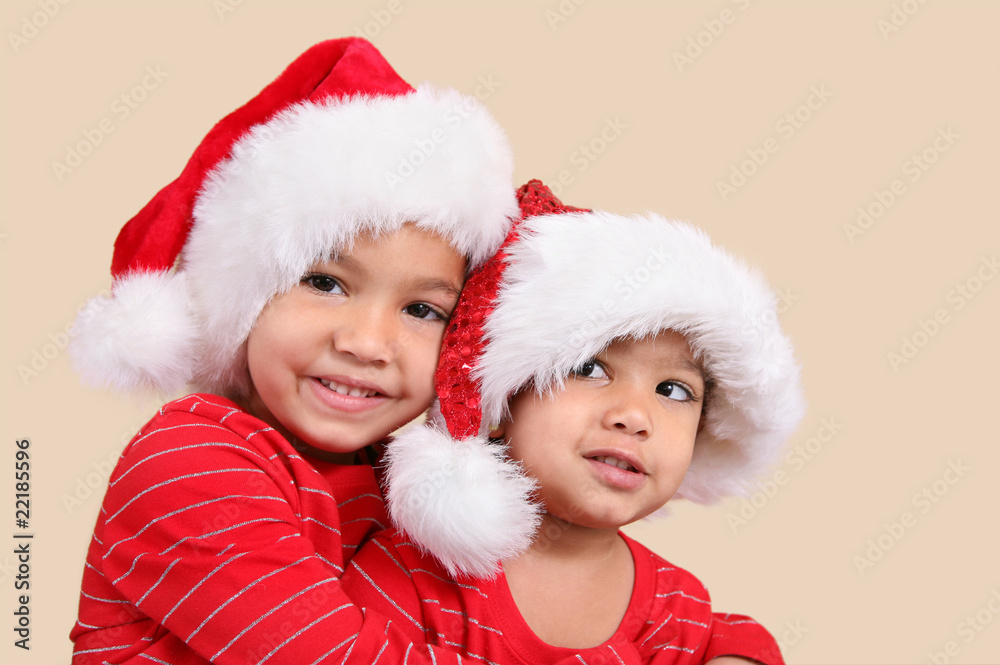 Two mixed race sisters in santa hats Two mixed race sisters in santa hats