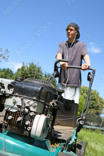 Teenage boy mowing lawn