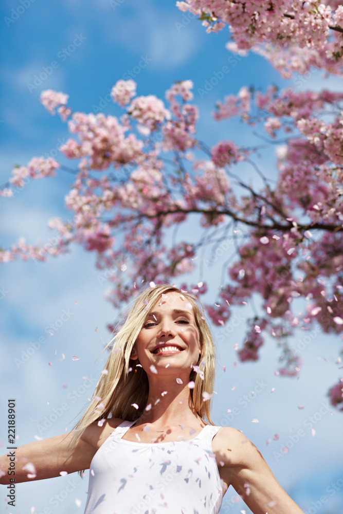 Fototapeta premium Lachende Frau unter Kirschbaum