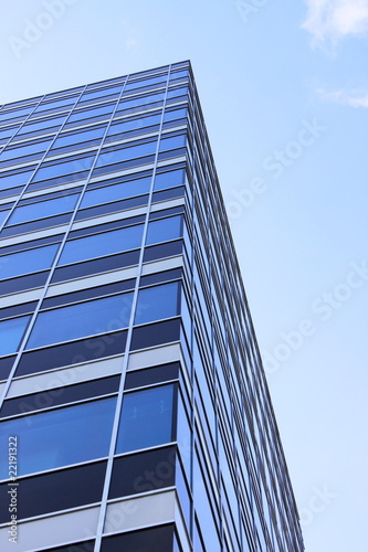 Modern glass skycraper on a blue sky background