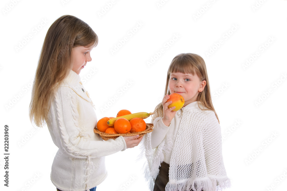 Two cheerful little girls with fruit on the white Two cheerful little girls with fruit on the white