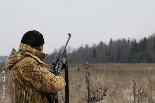 Huner with rifle waiting for animal