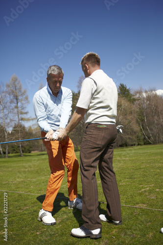 Golfer with a teacher practicing