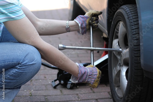 Eine Frau wechselt Reifen photo
