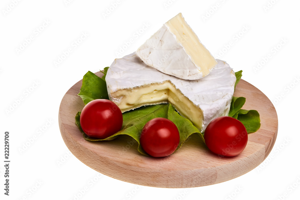 Round camembert cheese with lettuce and tomatoes. Round camembert cheese with lettuce and tomatoes.