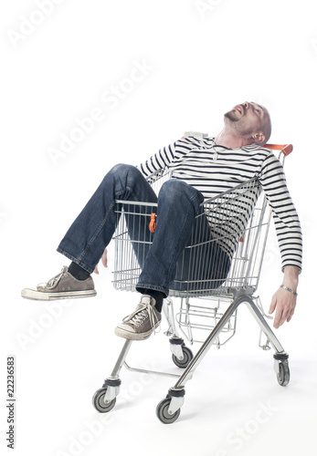 фотографія jeune homme dormant dans un caddie de supermarché