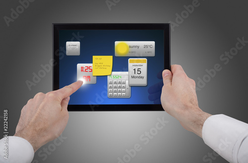 male hand holding a touchpad pc, using different programmes