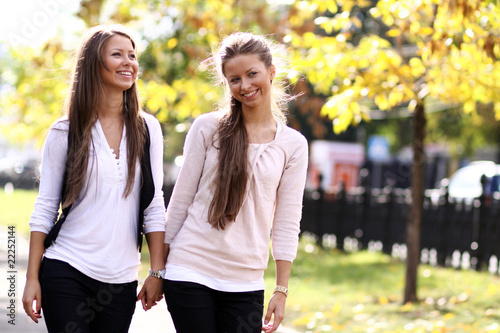 Two cheerful girls twins, in the street