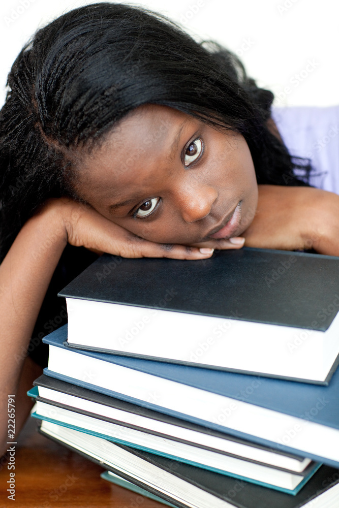 Tired student leaning on a stack of books Tired student leaning on a stack of books