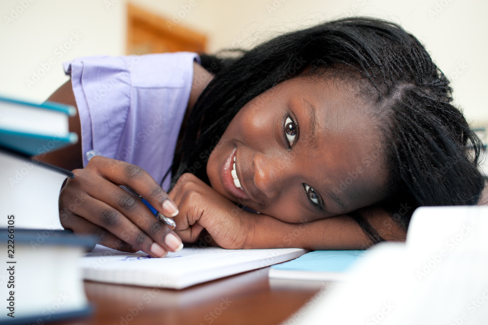 Cheerful teen girl doing her homework Cheerful teen girl doing her homework