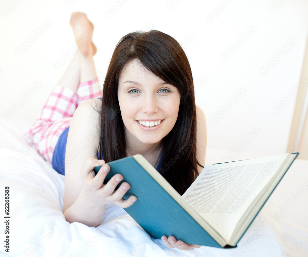 Portrait of a radiant teen girl studying lying on a bed Portrait of a radiant teen girl studying lying on a bed