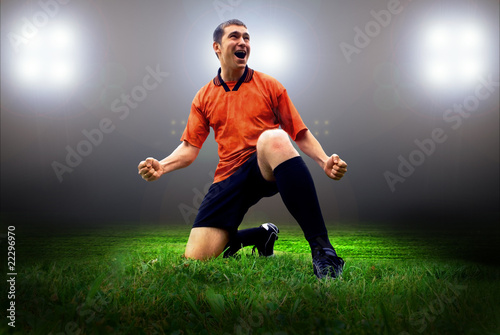 Happiness football player after goal on the field of stadium wit