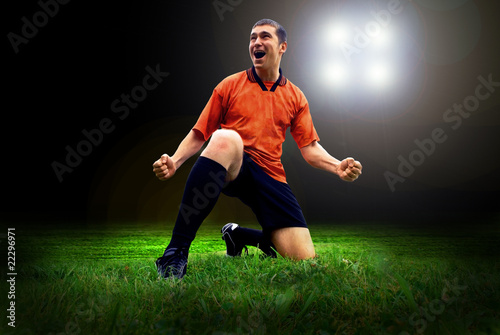 Happiness football player after goal on the field of stadium wit