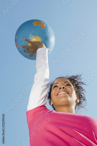 Hispanic woman holding globe ball photo