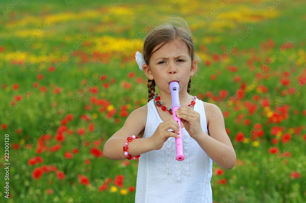 Pretty young girl playing the recorder in a poppy field Pretty young girl playing the recorder in a poppy field