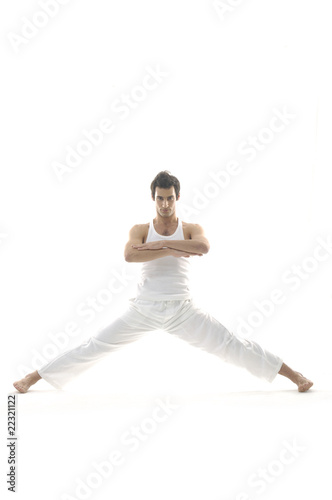 Happy young male in white clothes is jumping
