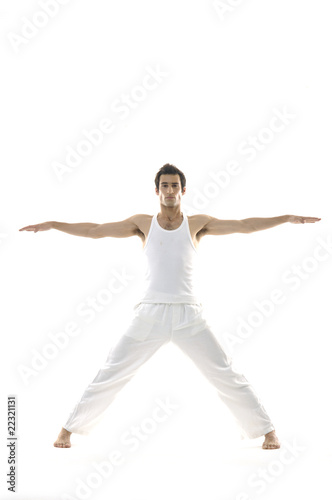young male in white clothes is jumping with hands up
