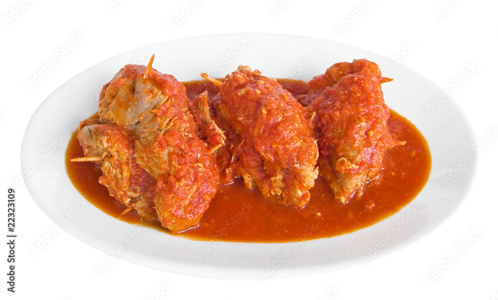 Meat roulade in tomato sauce on white dish.