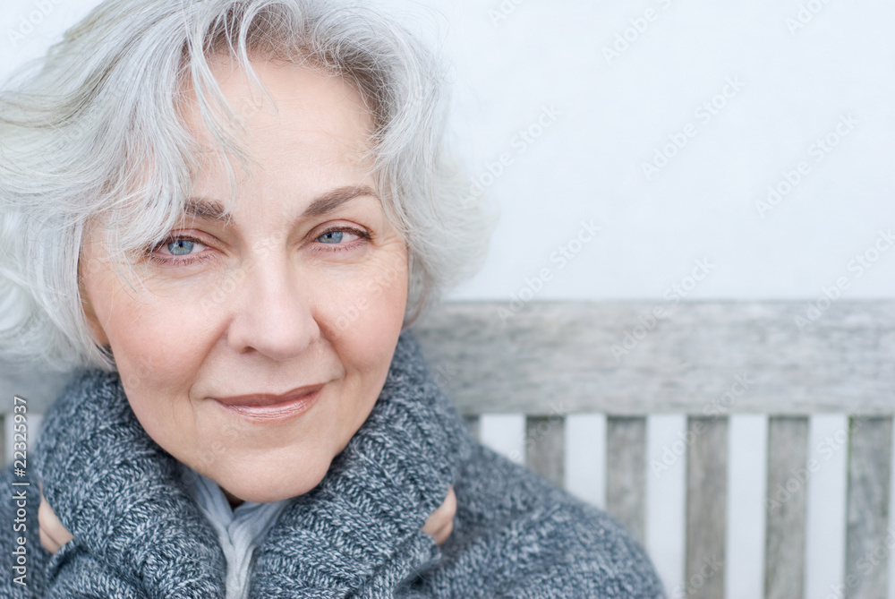 smiling senior woman on a bench smiling senior woman on a bench