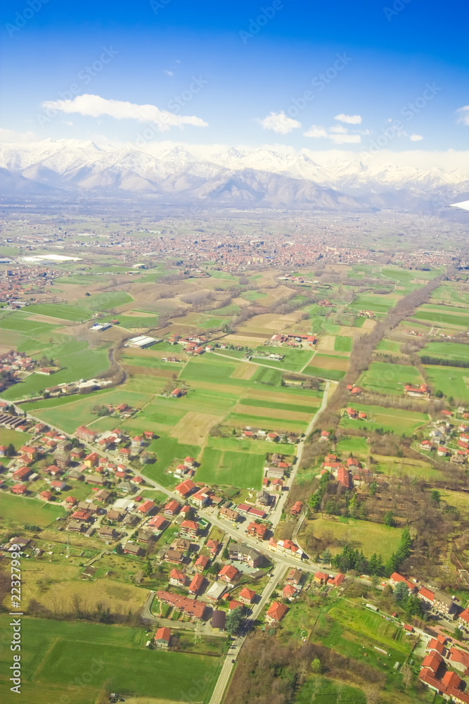 Aerial view of green rural landscape and houses with brown roofs