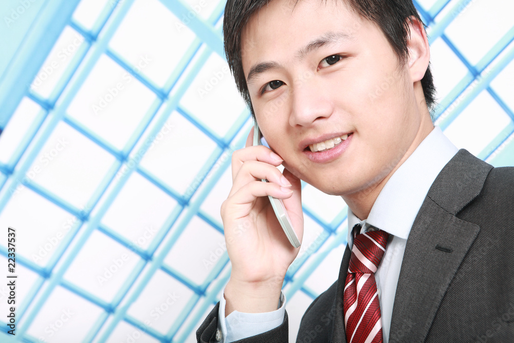 a businessman is standing in office and answering the phone a businessman is standing in office and answering the phone