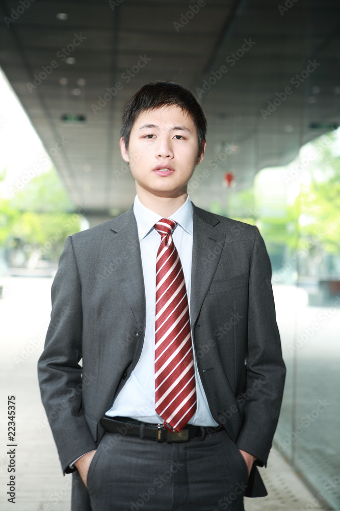a yong Asiatic businessman is walking outdoor at night a yong Asiatic businessman is walking outdoor at night