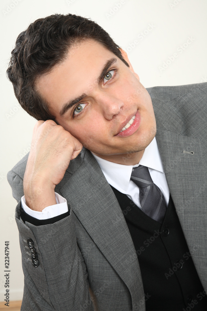 junger businessmann lehnt sich auf seine hand